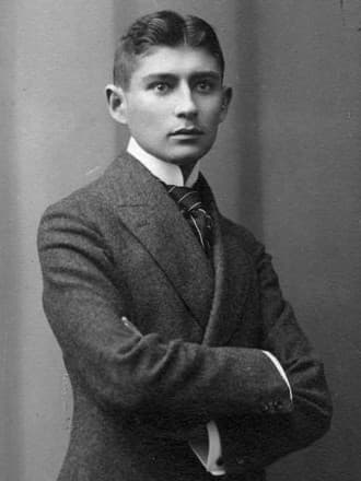 Photographic portrait of the young Franz Kafka in a dark suit and high collar.